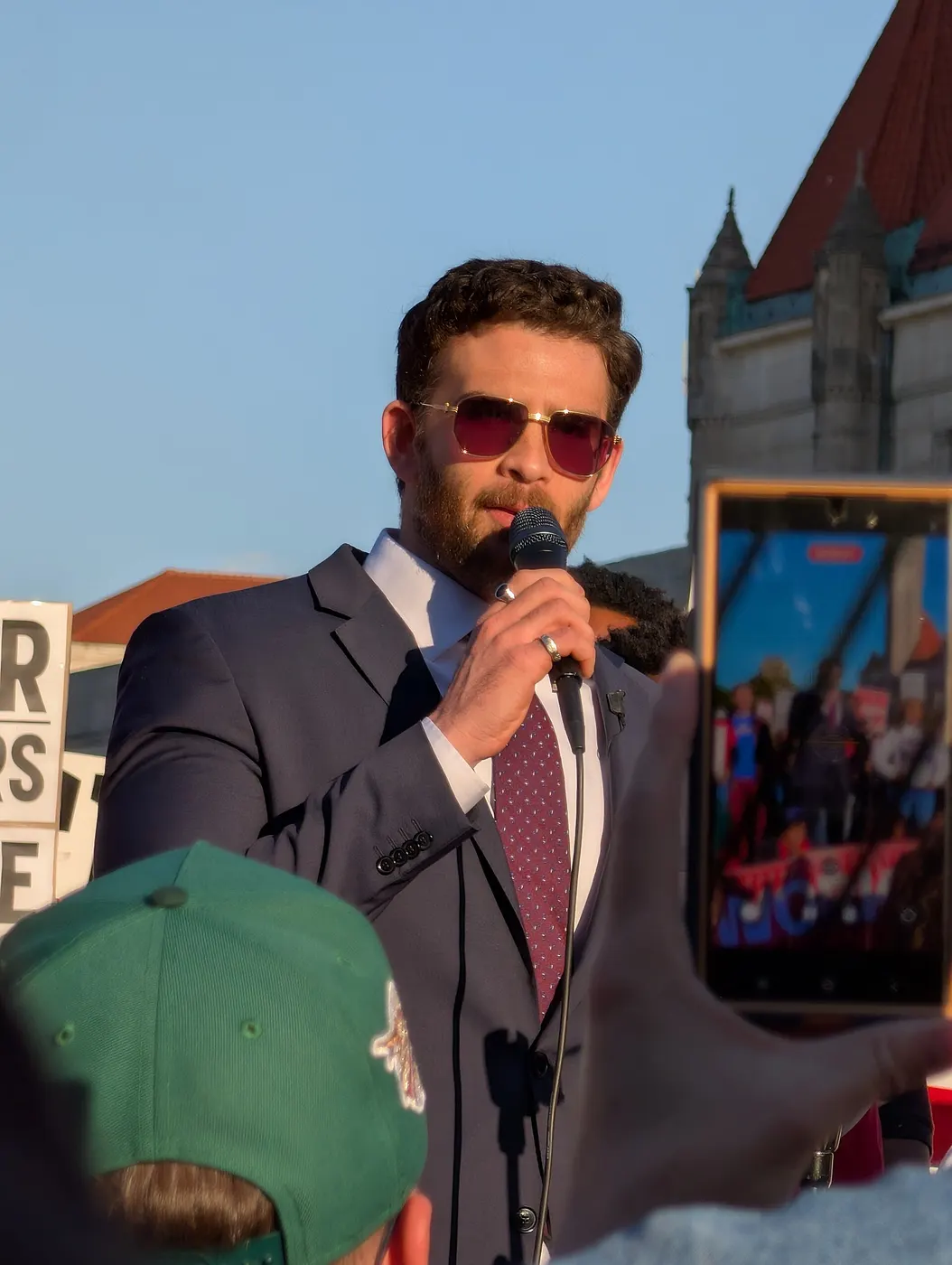 Hasan Piker gesturing while speaking at the Cori Bush rally in St. Louis